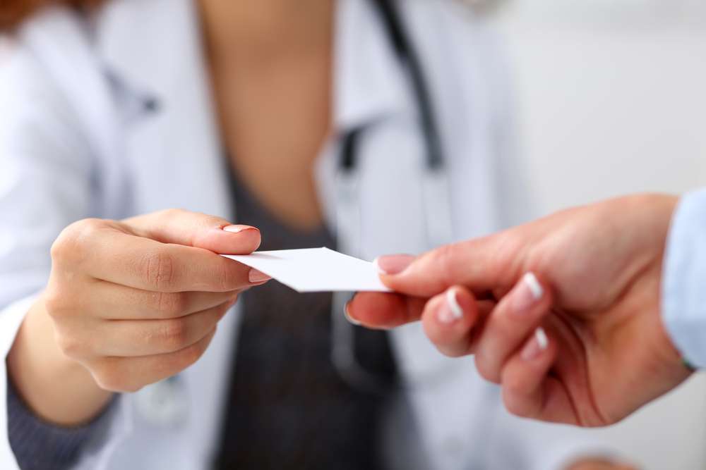 Female doctor receiving a note from a female patient