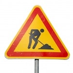 Person digging warning street sign