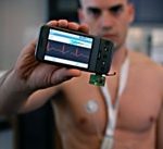 man in fitness holding heart rate monitor on iPhone