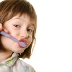 little girl brushing her teeth