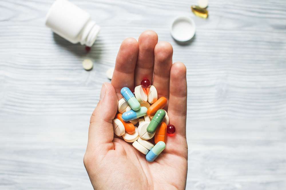 Person holding a handful of pills