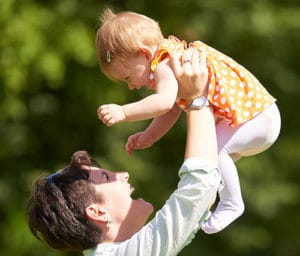 mother laughing and playing with baby