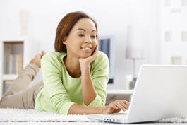 woman on bed looking at laptop