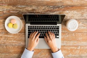 man typing on laptop on desk