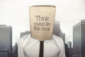 man with bag over head reading "Think outside the box"