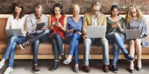 Group of people sitting in a row all looking at screens