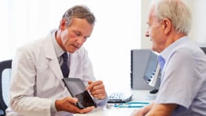 Senior Patient Having Consultation With Doctor In Office