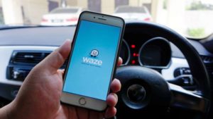 man holding phone using waze advertising app